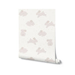 Roll of 'Nursery Bunny Wallpaper' showing a soothing design of beige bunnies and golden dots on a light background, ideal for creating a peaceful and charming environment in children's rooms