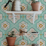 Wall-mounted shelves against a background of Fatima Tile Wallpaper with a detailed Moroccan tile design in turquoise, adorned with various houseplants and kitchen utensils.