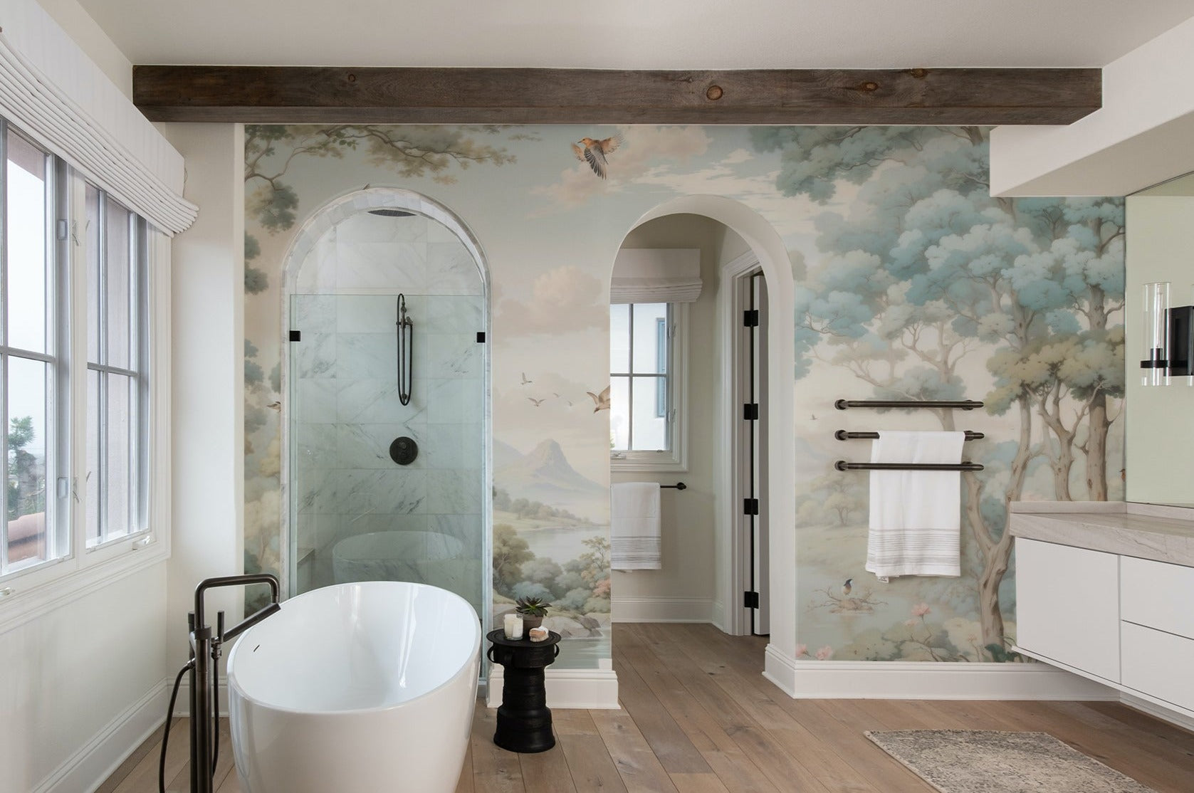 Modern bathroom enhanced with a Loire Valley landscape mural, featuring a freestanding bathtub and tranquil nature scenes."