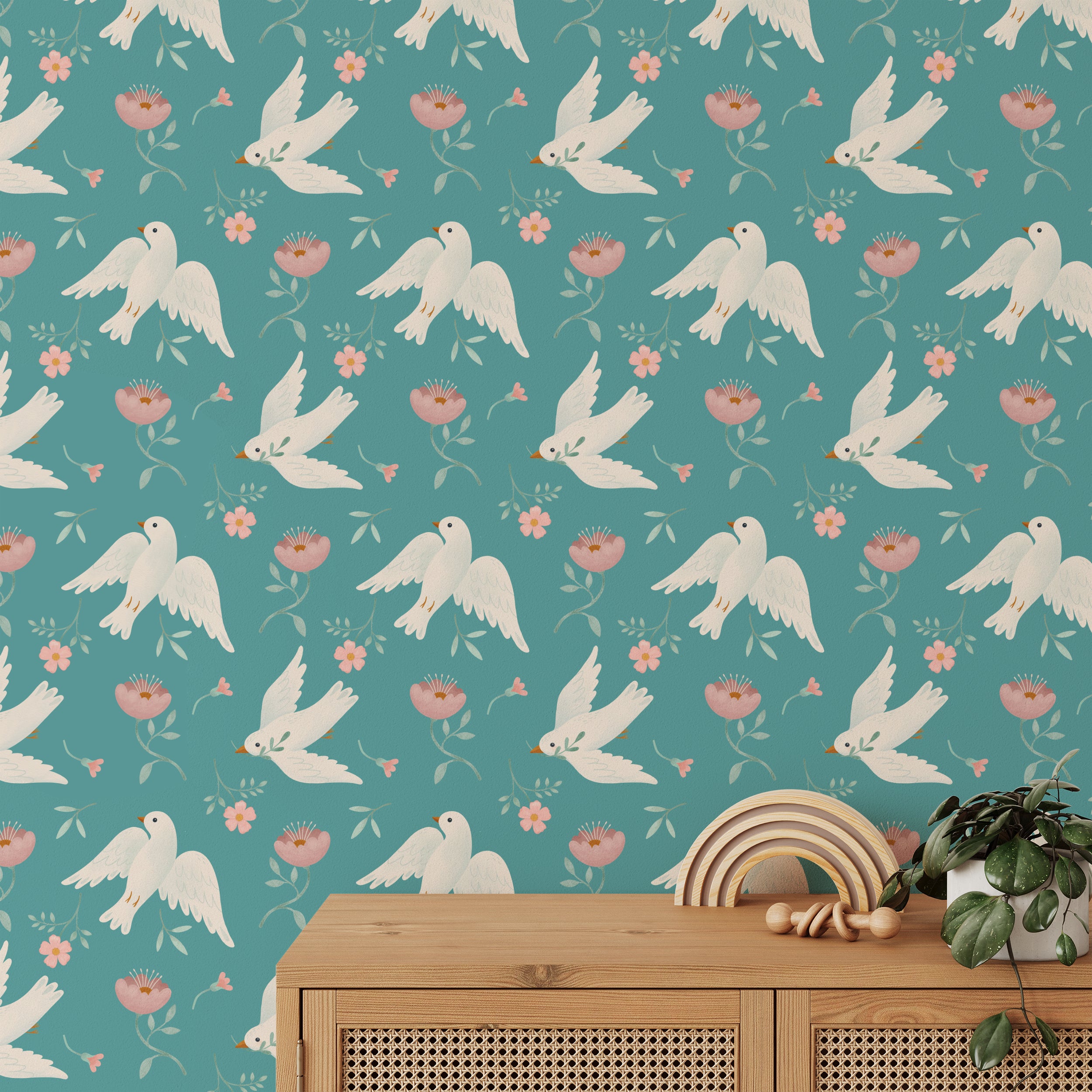Interior design featuring Singing Birds Wallpaper, showing white doves and pink flowers pattern against a teal backdrop, complementing a minimalist room with a wooden toy on a white cabinet.