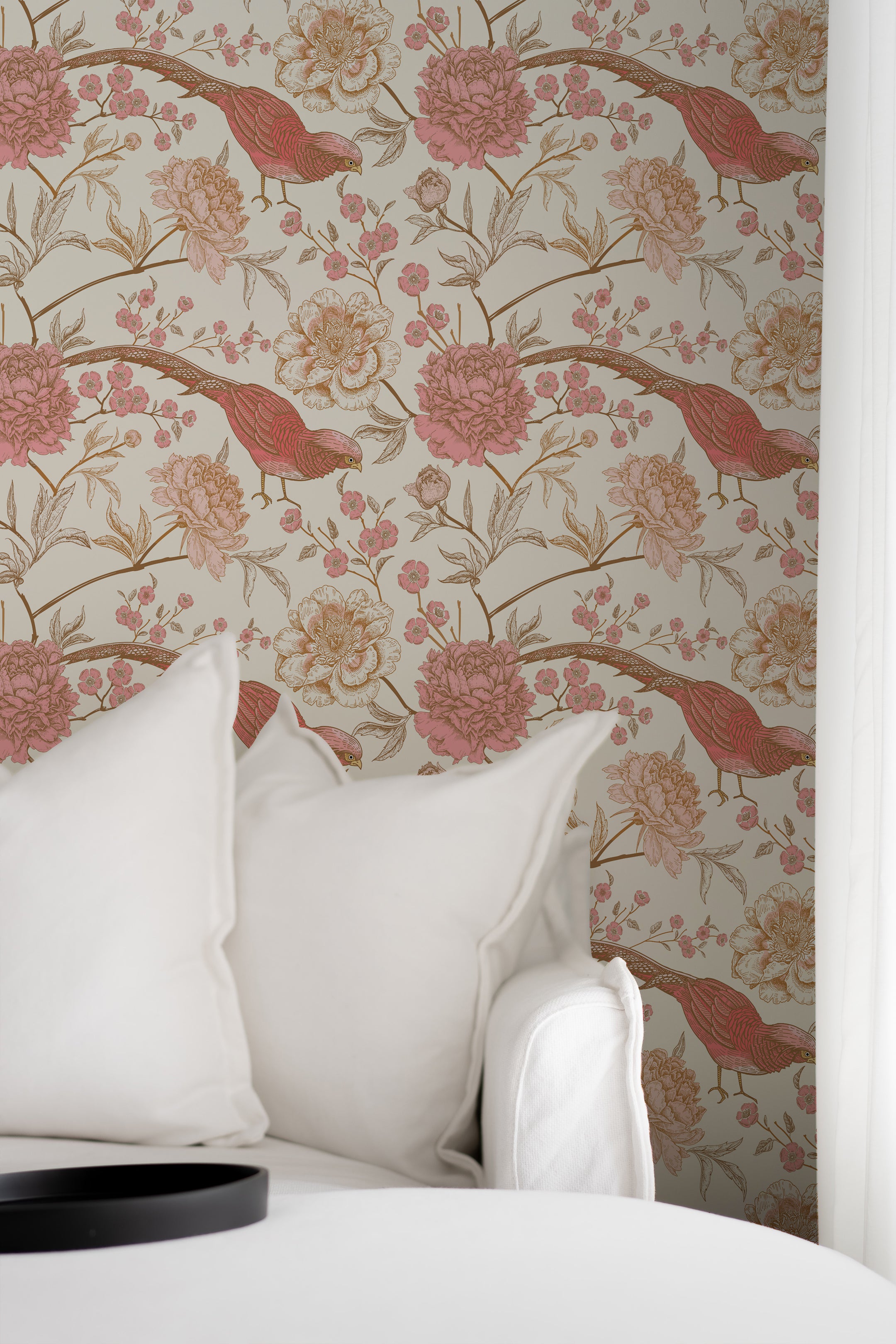 Cozy corner of a room decorated with Peonies and Pheasants Wallpaper, featuring red pheasants and pink peonies against a cream background. The scene includes soft white pillows, creating a tranquil and stylish ambiance