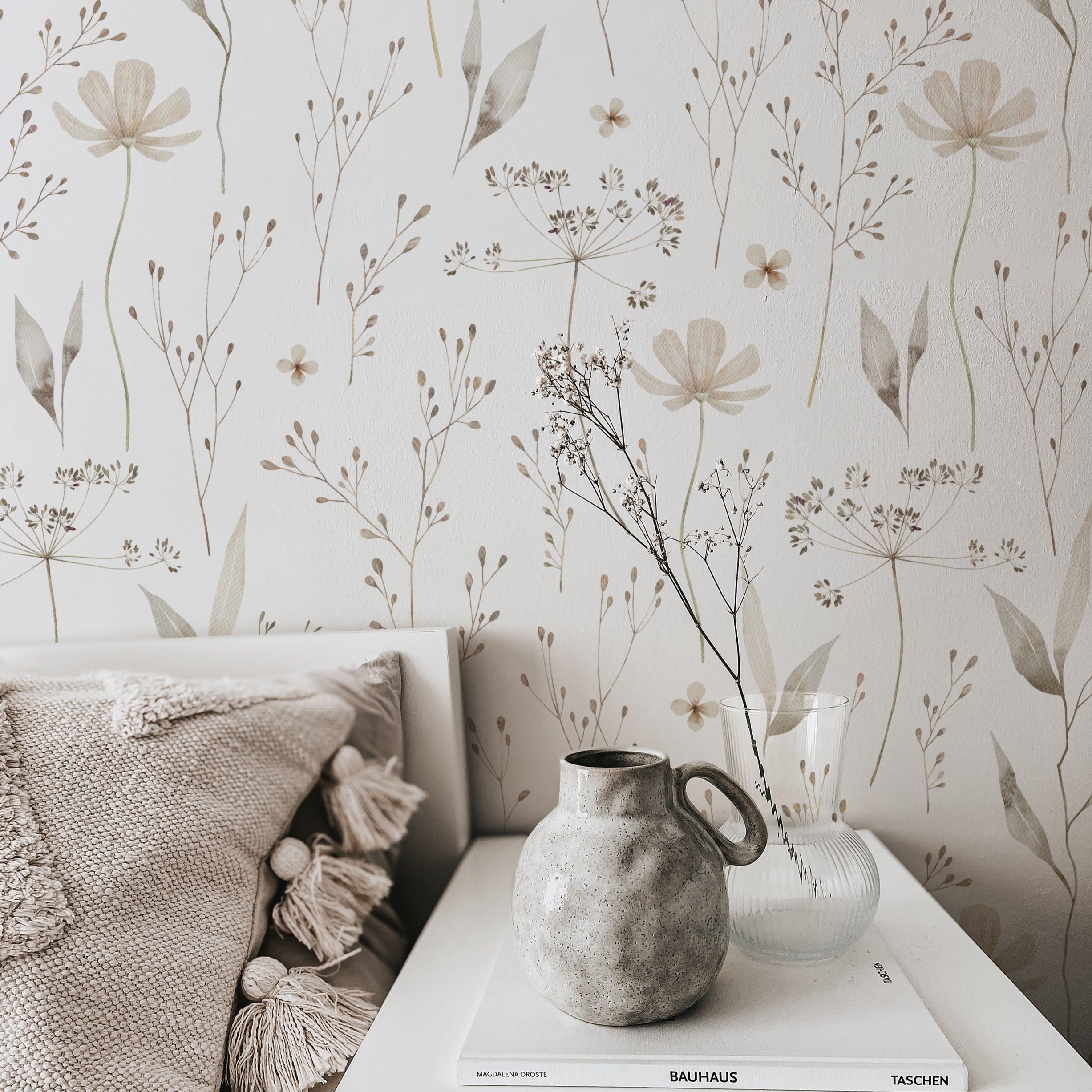 A cozy corner with Tranquil Bloom Wallpaper, illustrating a delicate botanical design of slender flora and pastel flowers that provide a sense of calm and a touch of nature's quiet beauty to the room.