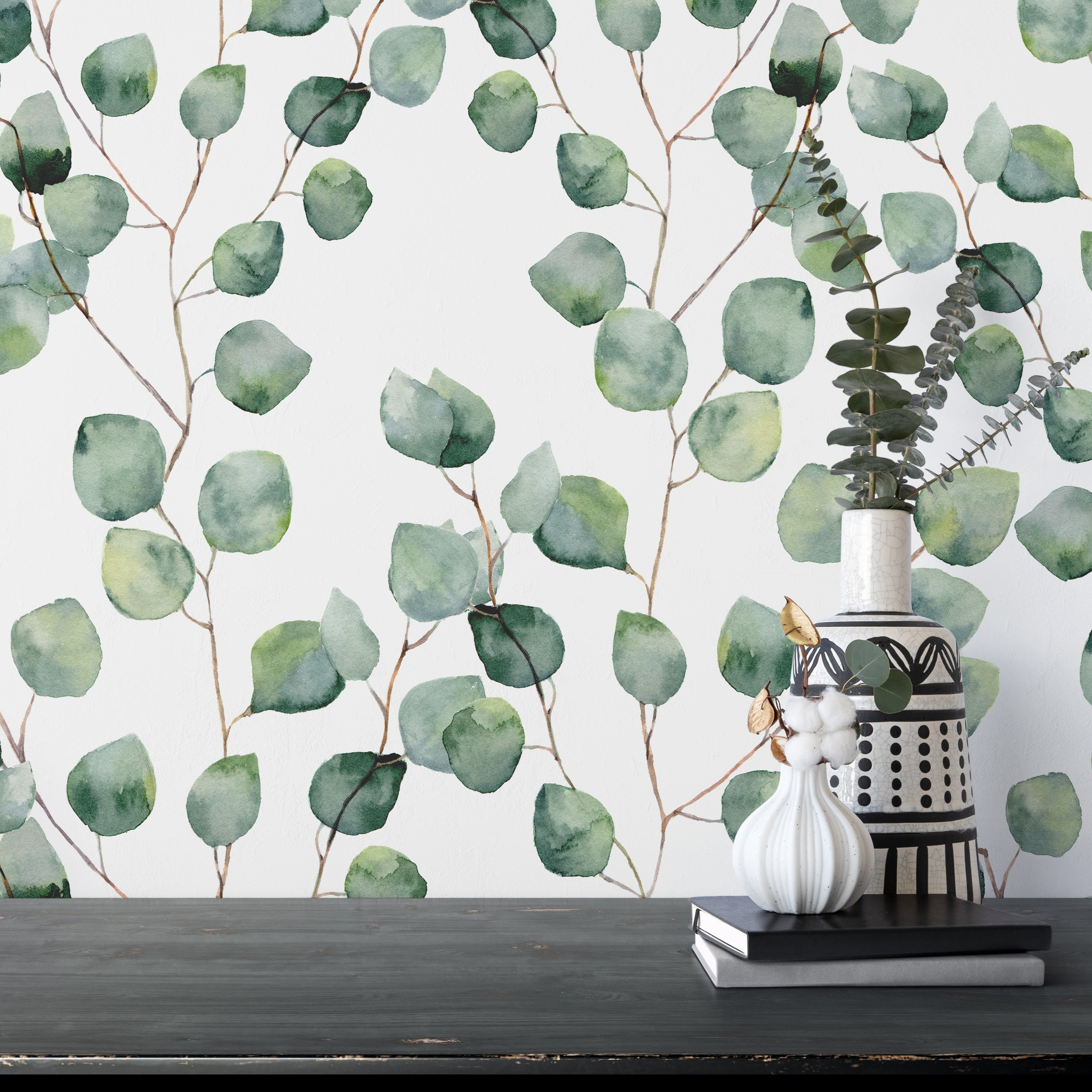 The Watercolour Floral Wallpaper - Eucalyptus features a detailed pattern of eucalyptus branches in various shades of green, adding a tranquil and natural touch to the wall.