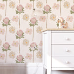 A charming children's room featuring walls covered in 'Retro Pastel Flower Wallpaper' with a repeating pattern of pink clover flowers and pale pastel daisies on a light background, creating a serene and inviting atmosphere