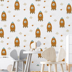 Child's playroom featuring walls adorned with Rocket Time Wallpaper, showcasing multiple orange rockets with teddy bear astronauts, interspersed with clouds and stars, complementing the playful and imaginative decor