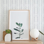 Close-up view of the Hand Painted Chevron Wallpaper detailing the unique brush strokes in a chevron pattern, complemented by framed artwork and decor.
