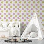 Room setup with a wall covered in cat-themed wallpaper displaying a sequence of pink and yellow cats with black accents. The room features a white teepee with star details and a plush polar bear, creating a cozy and imaginative children's play area