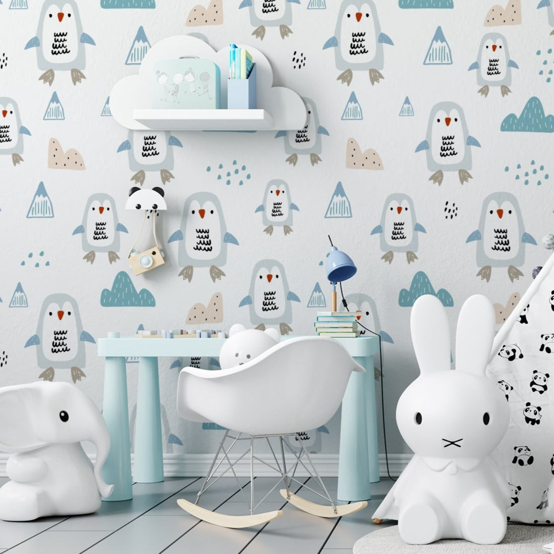 A playful children's room decorated with "Nordic Penguin Wallpaper," featuring a pattern of adorable cartoon penguins and small geometric mountain shapes in shades of blue, beige, and gray. The room is equipped with a white tent, children's furniture, and whimsical toys like a large elephant and rabbit figures, creating a fun and engaging atmosphere.