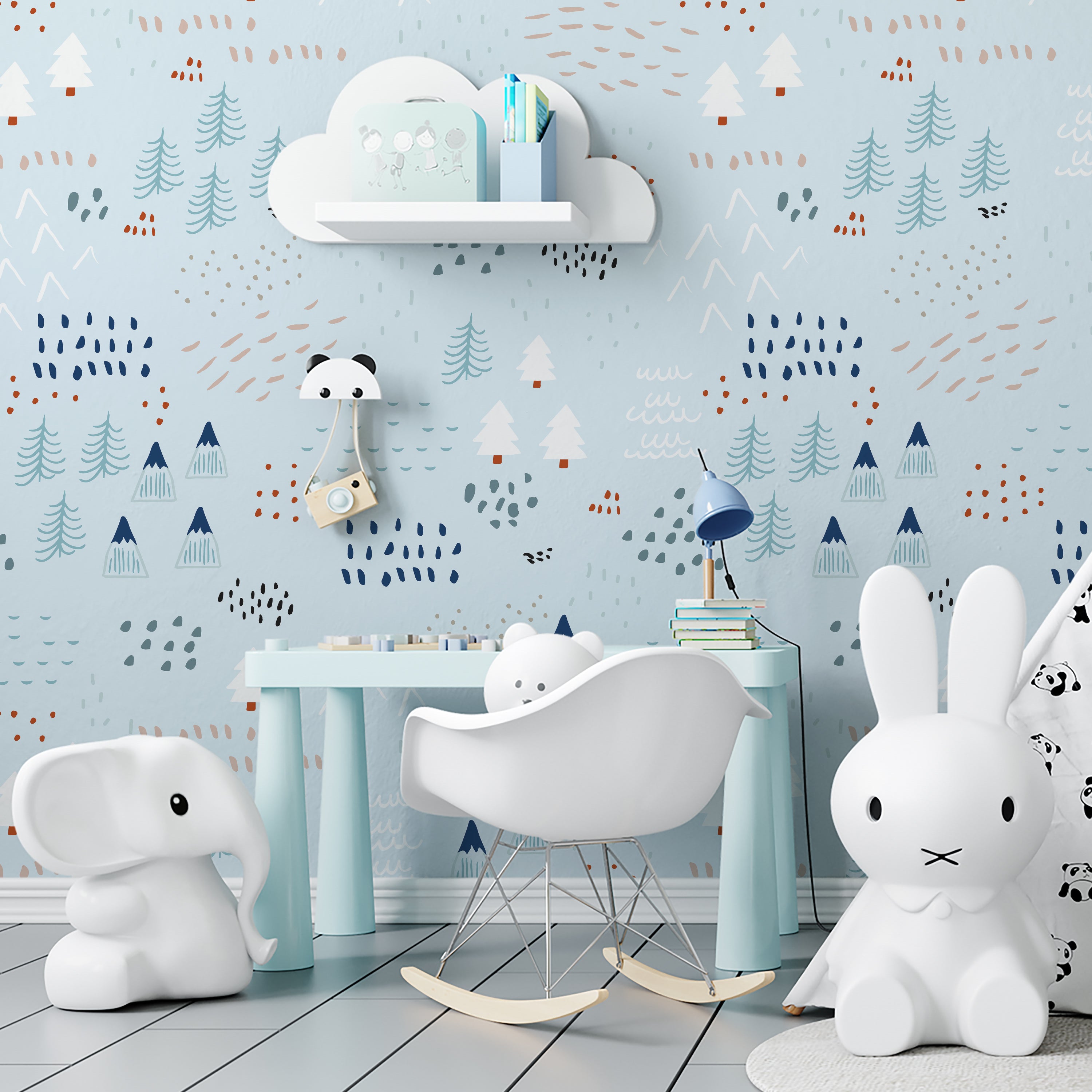 A children's playroom adorned with the "Nordic Adventure Wallpaper," which provides a backdrop of abstract trees and mountains in shades of blue, white, and orange. The room is equipped with modern children's furniture including a white elephant rocker, a cloud-shaped shelf, and playful decorations that complement the adventurous theme of the wallpaper.