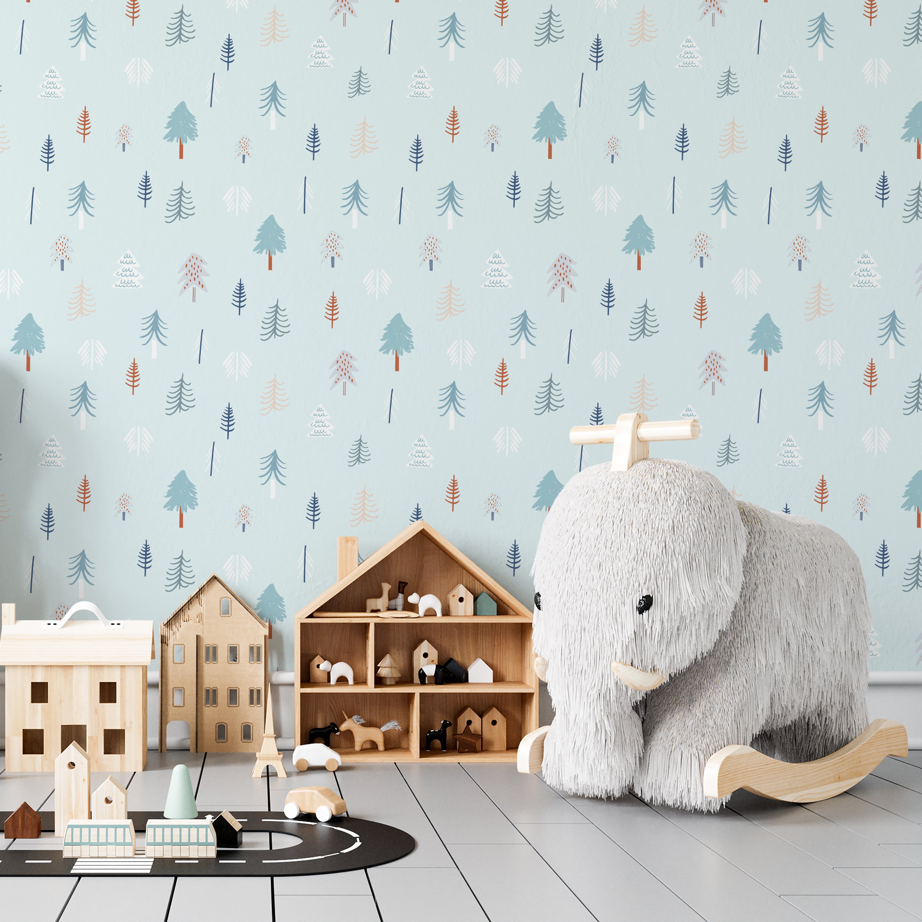 A child’s playroom featuring walls adorned with the "Nordic Tree Wallpaper" displaying a soothing array of stylized trees on a light blue background. The room includes wooden toys, a plush polar bear rocker, and a small wooden playhouse, creating a serene and playful environment.
