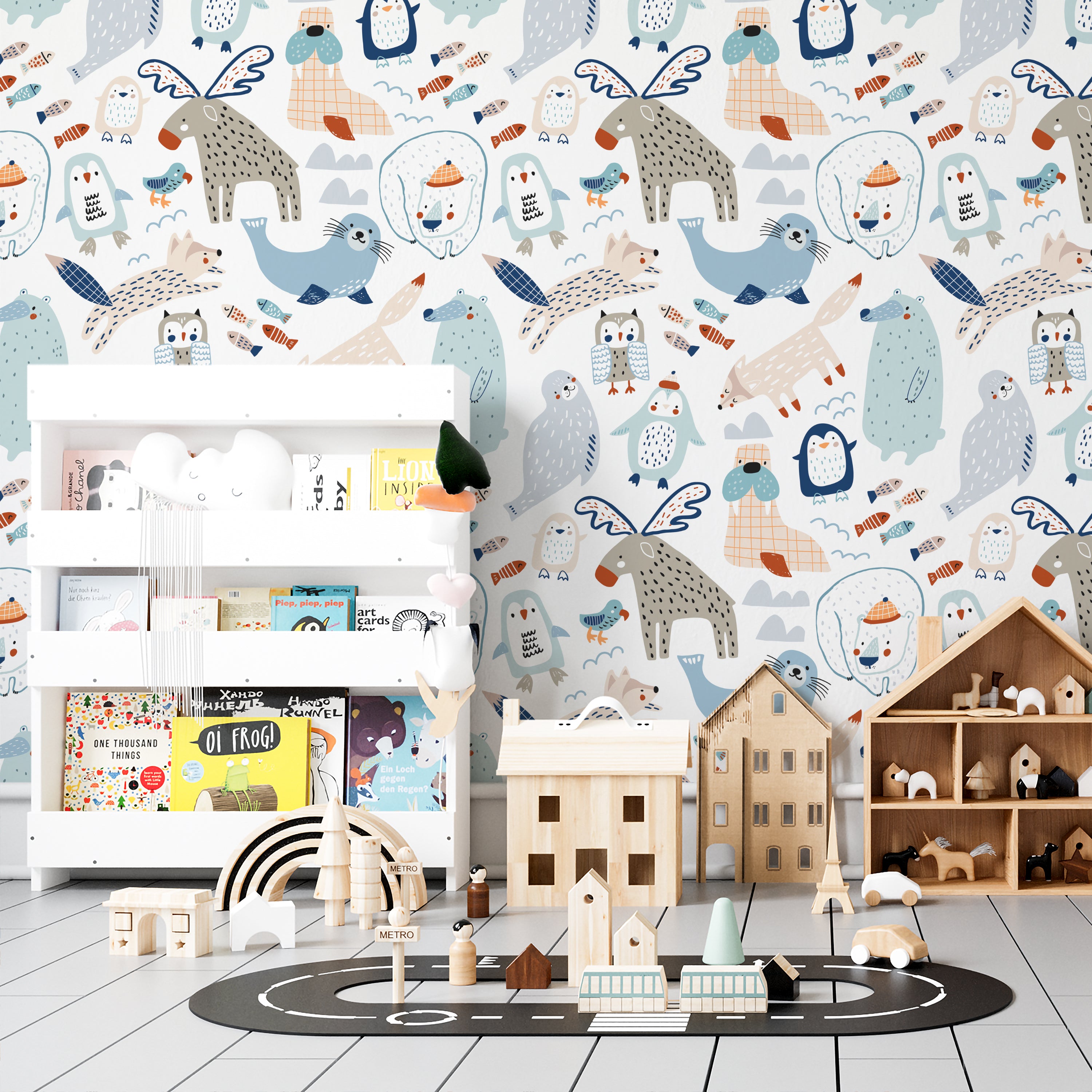 A nursery room decorated with "Nordic Moose Wallpaper" showing a vibrant and playful animal pattern. The room includes a white bookshelf filled with children's books and toys, a wooden playhouse, and a toy car track, all complemented by the cheerful wall design.