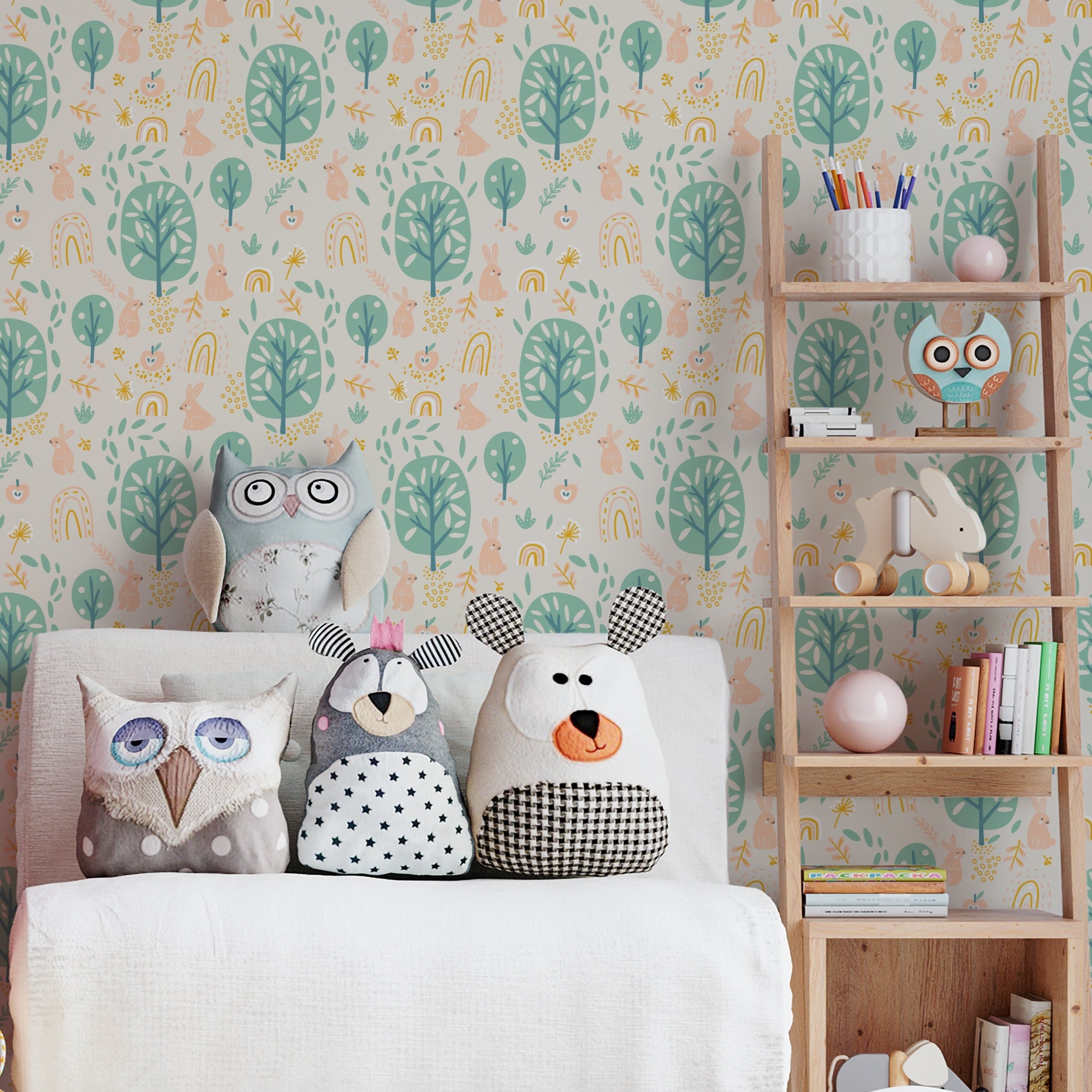 Children's playroom decorated with wallpaper featuring a soft peach background adorned with white rabbits, green trees, and subtle rainbow motifs, complemented by stuffed animal toys and wooden furniture.