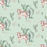 Watercolor Farm Animals III wallpaper showcasing playful patches of brown and white cows among watercolor green trees and soft, scattered stones on a serene mint green background