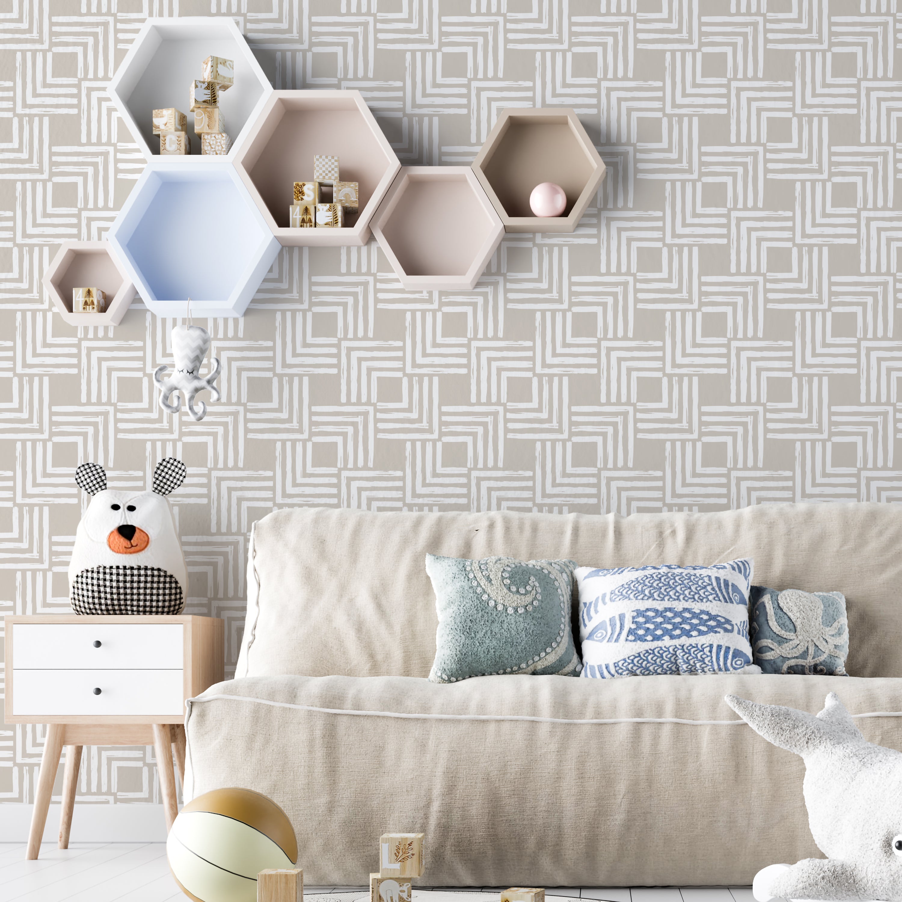 A cozy living room decorated with Organic Wallpaper 3 on the wall, displaying an abstract pattern in taupe. The room includes a beige sofa with decorative cushions, playful stuffed toys, and hexagonal wall shelves, creating a warm, inviting ambiance