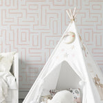 A child's nursery room wall covered with Organic Wallpaper 19, displaying a maze-like pink line pattern. The room includes a white play tent adorned with plush toys and star decorations, creating a playful and inviting atmosphere