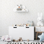 Children's nursery with playful and modern design, featuring a large white toy storage bin with various stuffed animals and a whimsical cloud-shaped shelf on a patterned wallpaper background. The wallpaper has a subtle, abstract geometric pattern in a neutral color palette