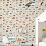 A child's playroom wall covered with Cute Trucks and Cars Wallpaper, decorated with a variety of whimsical vehicles in a soft color palette. The background features stylized representations of buses, cars, and trucks, adding a cheerful and engaging element to the room.