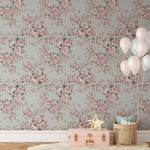 A stylish living area with Rose Bouquet Wallpaper II, featuring pink roses and green leaves on a light blue background. The decor includes a wicker basket, balloons, and a pink toy chest.