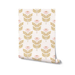 A roll of Ditsy Daisy Wallpaper, displaying a pattern of petite pink flowers and greenery on a light base. This wallpaper brings a fresh, floral elegance to walls, perfect for nurseries, bedrooms, or quaint sitting areas