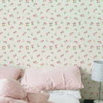 A cozy bedroom enhanced by the Flora Wallpaper, which features a quaint pattern of tiny pink flowers and green foliage against a light background. The room is styled with pink and white bedding and a plush duvet, creating a warm and inviting atmosphere.