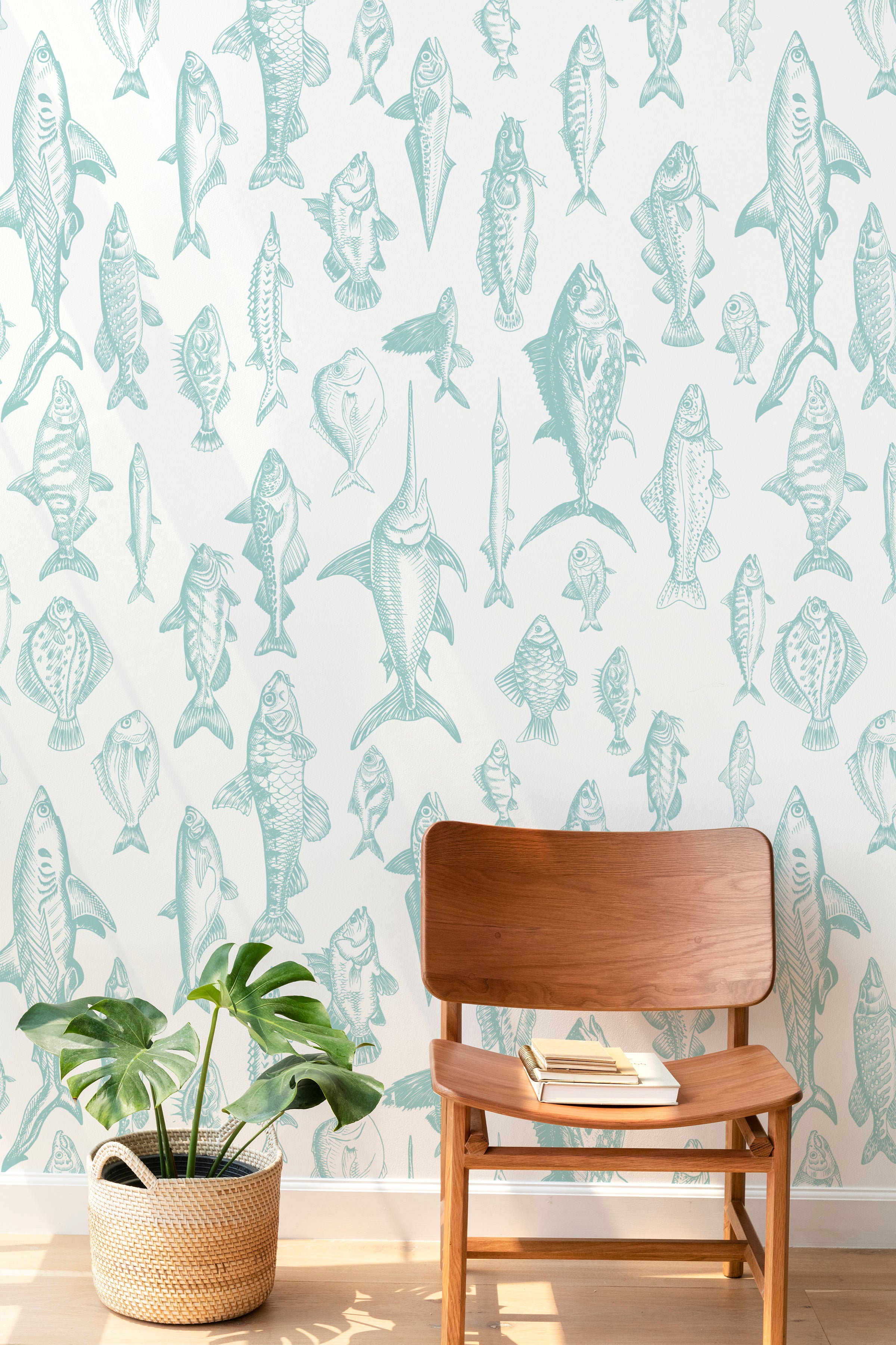 Contemporary living space with a mid-century modern chair and potted plant, complemented by a wall covered in detailed fish illustrations on wallpaper.