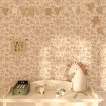 The space includes the floral wallpaper, a plush toy on a white dresser, decorative flags, and soft lighting, providing a playful yet calming ambiance.