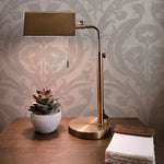 An elegant workspace showcasing the Regal Elegance Wallpaper as a backdrop. A stylish brass desk lamp with a rectangular shade illuminates a succulent in a white pot and a handmade journal, creating a serene and cultivated work environment.