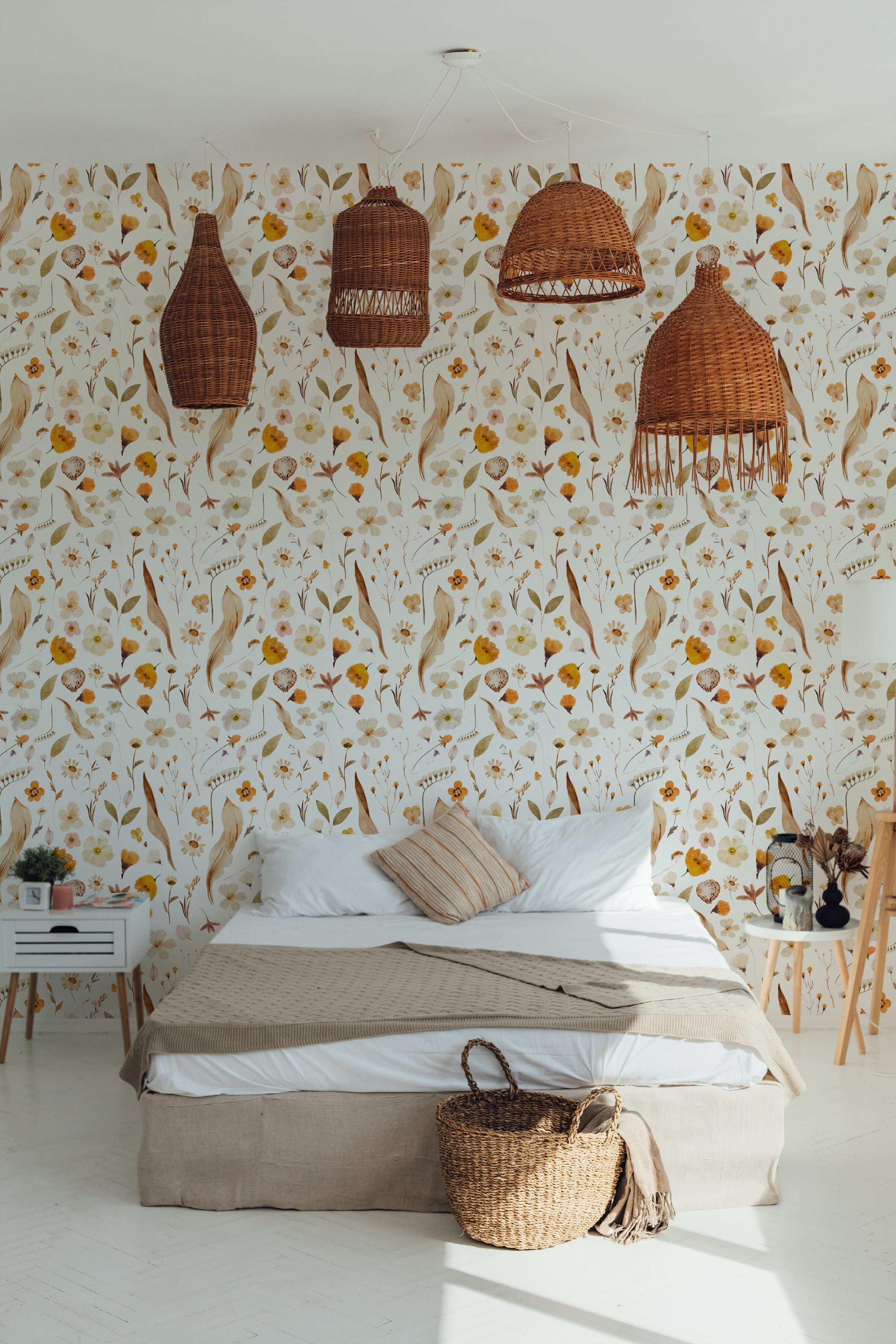 A serene bedroom featuring Boho Dreams Wallpaper adorned with a rich botanical pattern of flowers and leaves in warm earth tones. The room is accented with wicker pendant lamps, enhancing the natural, bohemian vibe.