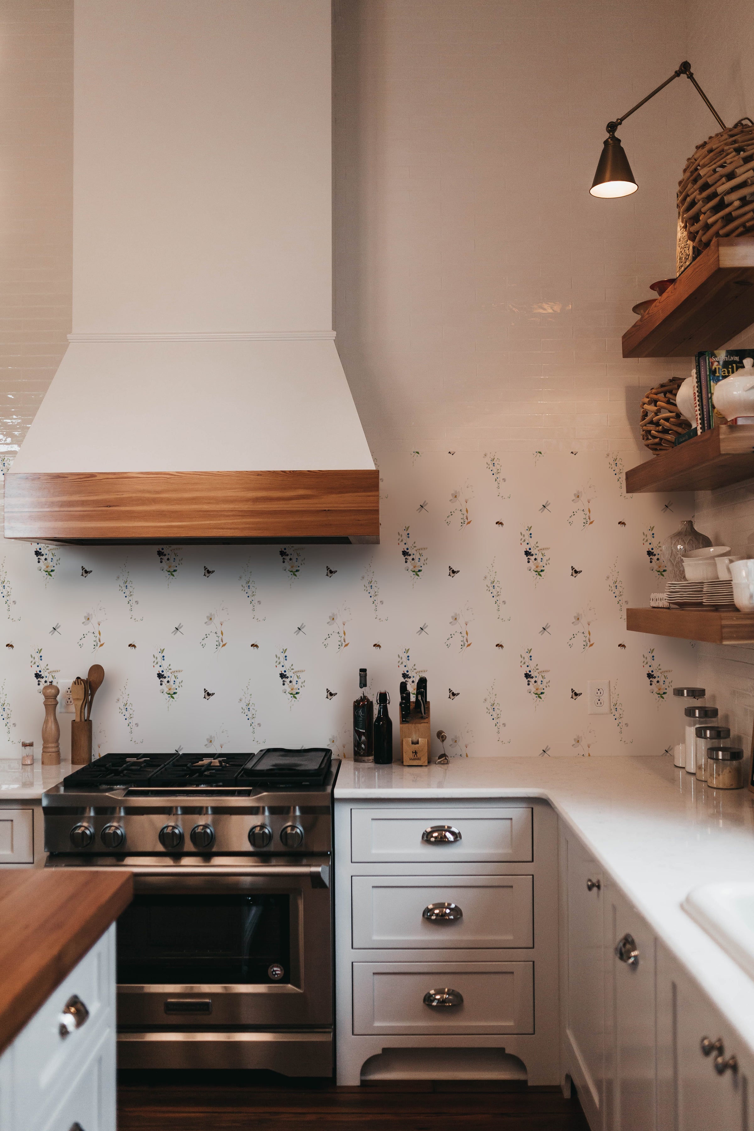 A modern kitchen setup with the "Berry Spring Wallpaper" providing a lively backdrop. The kitchen features sleek cabinetry and a professional-grade stove, with the playful and naturalistic wallpaper pattern adding a touch of whimsy and charm.