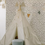 A child's play area with a tent under a string of lights, set against a wall covered in Sweet Watercolour Floral Wallpaper. The wallpaper's soft floral patterns create a soothing backdrop, enhancing the playful yet peaceful setting.