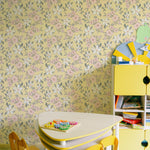 A vibrant children's playroom decorated with the Sunny Nursery Wallpaper, featuring a playful floral pattern on a yellow background, complemented by a kid-sized table and chairs, enhancing the space's lively and inviting atmosphere.