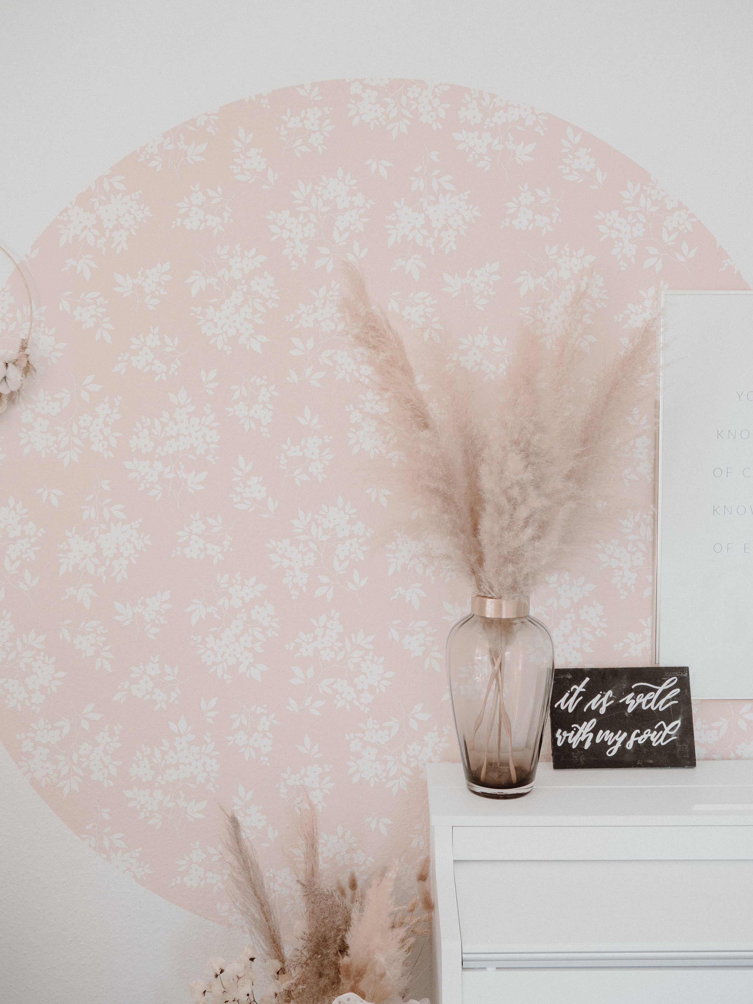 A stylish room corner featuring the Vintage Garden Floral Wallpaper in champagne. The wall is complemented by a rustic vase filled with pampas grass and a motivational quote sign, creating a cozy and inspirational space.