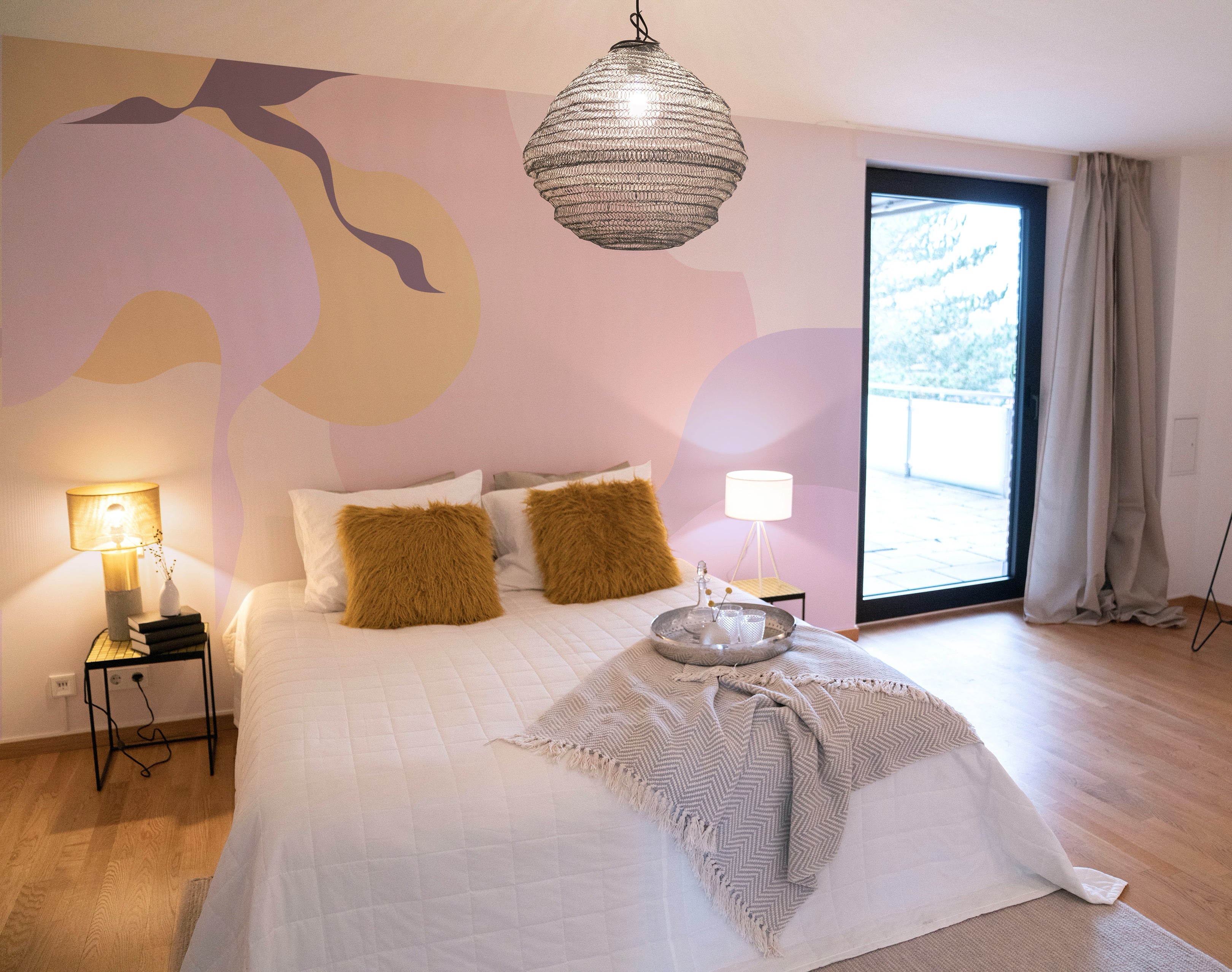 A cozy bedroom setting showcasing the Contemporary Art - Abstract Wall Mural. The mural's soothing palette and fluid abstract design create a tranquil ambiance, enhanced by soft bedding, stylish furnishings, and a direct view to an outdoor terrace.
