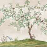 The Chinoiserie - Wallpaper Mural featured in an elegantly styled bedroom. The mural, with its detailed depictions of trees, birds, and blossoms, extends across the wall behind twin beds, complementing the natural wood elements and soft white bedding, creating a tranquil and luxurious sleeping environment.
