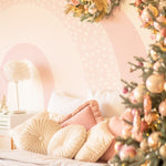 A festive holiday bedroom scene with Cute Rainbow Wallpaper Mural - Celeste adorning the wall. The mural features soft pastel rainbow arches with a dotted pattern, enhancing the warmth of the room decorated with Christmas elements, including a fully adorned tree and floral wreath.