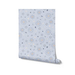 A roll of Blue Floral Joy Wallpaper showcasing its charming pattern with white flowers, stars, and crescent moons on a blue background. The image represents the wallpaper's soft and enchanting design, perfect for adding a touch of whimsy to any room.