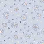 A detailed view of the Blue Floral Joy Wallpaper, displaying a whimsical pattern of small white flowers and celestial elements like stars and crescent moons in golden hues on a soft blue background. The design offers a magical and serene atmosphere suitable for nurseries or children's rooms.