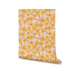 Rolled view of Abstract Meadow Wallpaper, illustrating the whimsical floral pattern with yellow blooms on a pink backdrop. The roll is slightly uncurled, showing the repeat pattern ready to transform any room with its charming and sunny disposition.