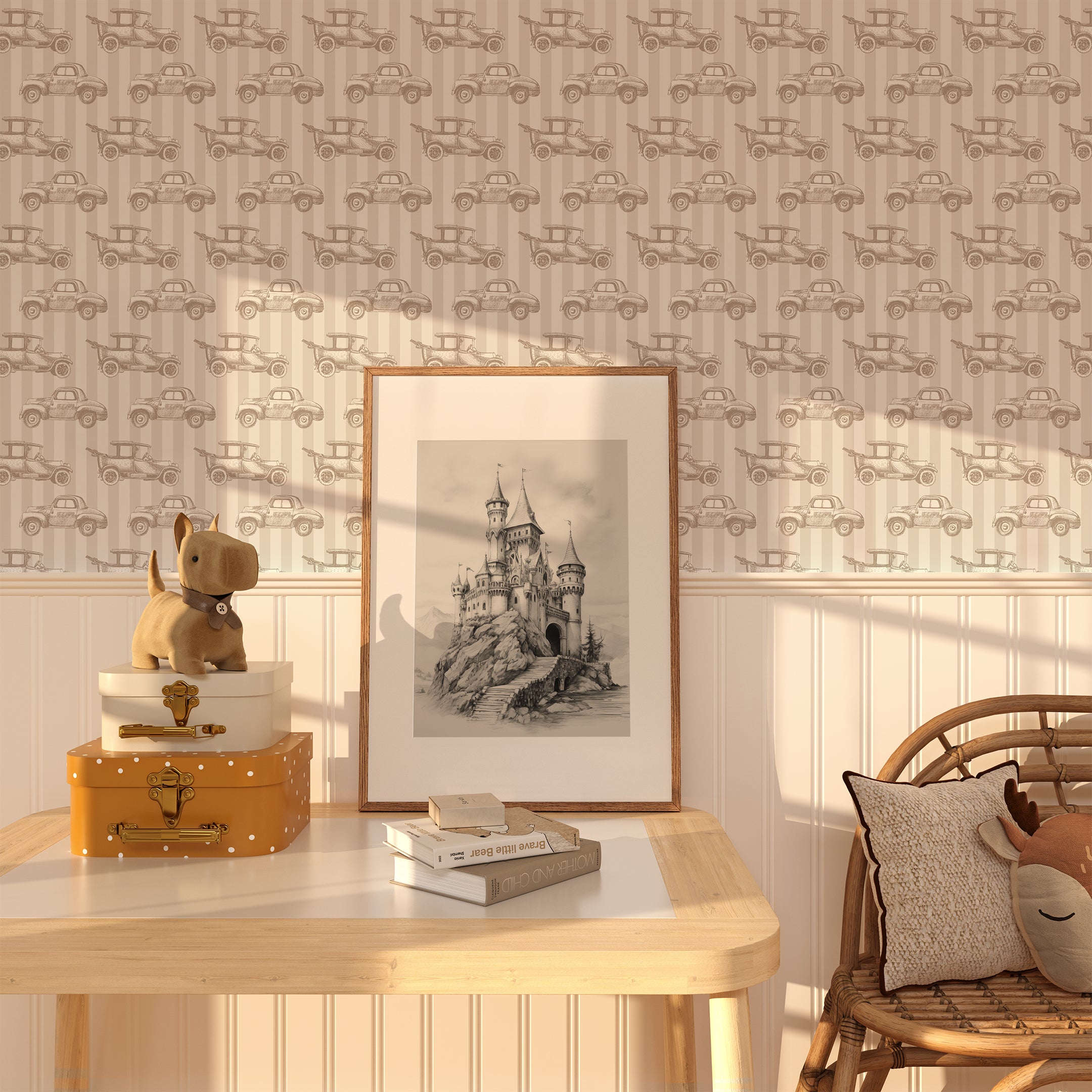 A charming room featuring the Antique Auto Wallpaper in beige. The wallpaper displays vintage car illustrations in a repeating pattern. The room includes a wooden table with stacked suitcases, a plush dog toy, and a framed sketch of a castle.