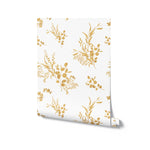 A roll of Golden Greenery Wallpaper shown upright with the detailed golden botanical pattern on a light background, ideal for adding an elegant touch to any room with its lush, nature-inspired design.