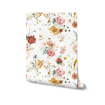 A rolled-up piece of Garden Flower Wallpaper III, illustrating the delicate watercolor flowers and foliage design in soft hues of pink, yellow, red, and blue on a white background, suitable for interior decoration.
