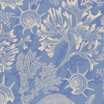 A detailed view of the Coastal Treasures Wallpaper showcasing its intricate pattern of seashells, coral, and sea plants in beige on a blue background. The design is detailed and nature-inspired, perfect for adding a touch of coastal elegance to any room.