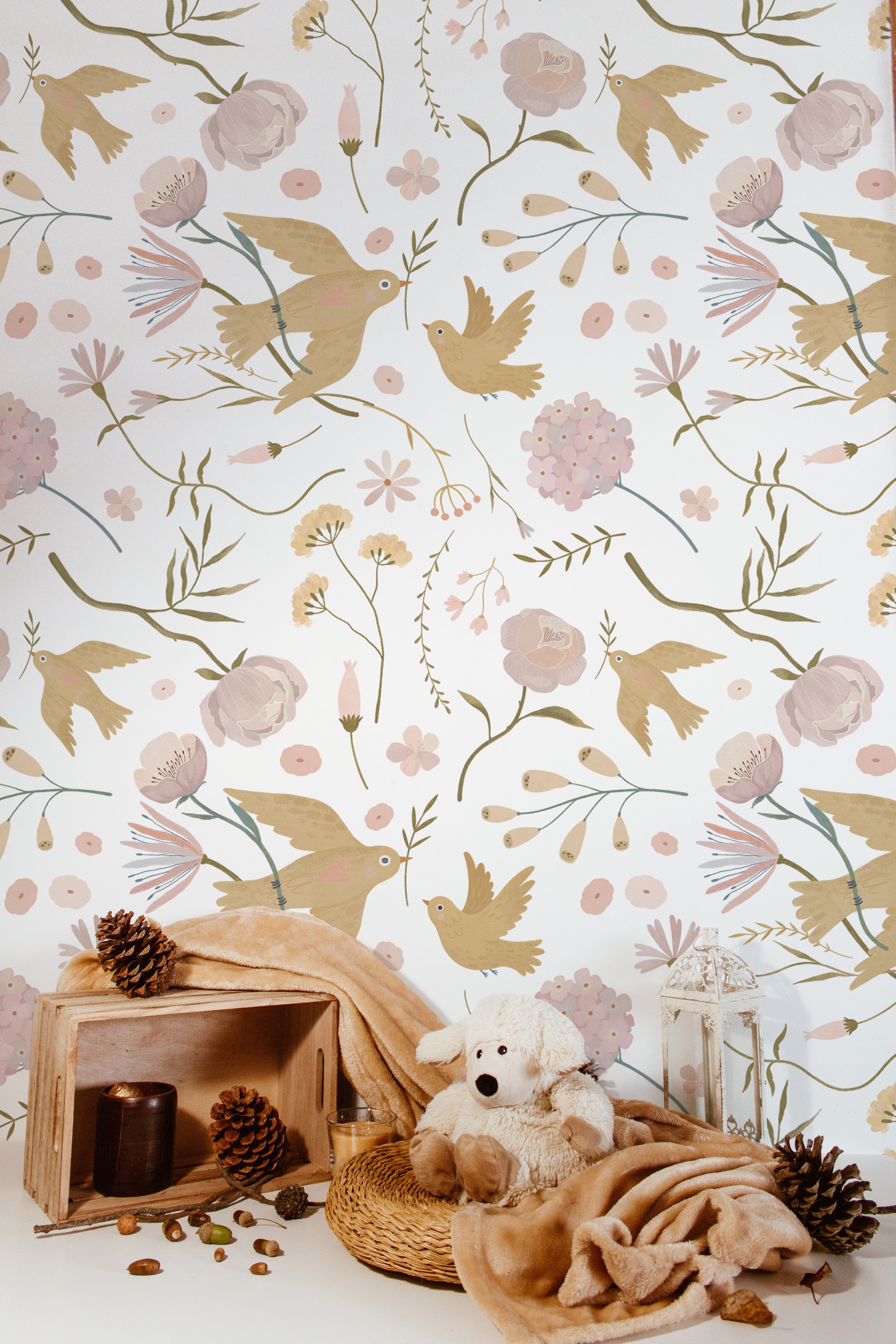Children's nursery adorned with Pastel Garden Wallpaper II - 25 inch, showcasing whimsical bird and flower illustrations in gentle pastel shades. A plush toy and natural decorations complement the serene and inviting ambiance of the room.