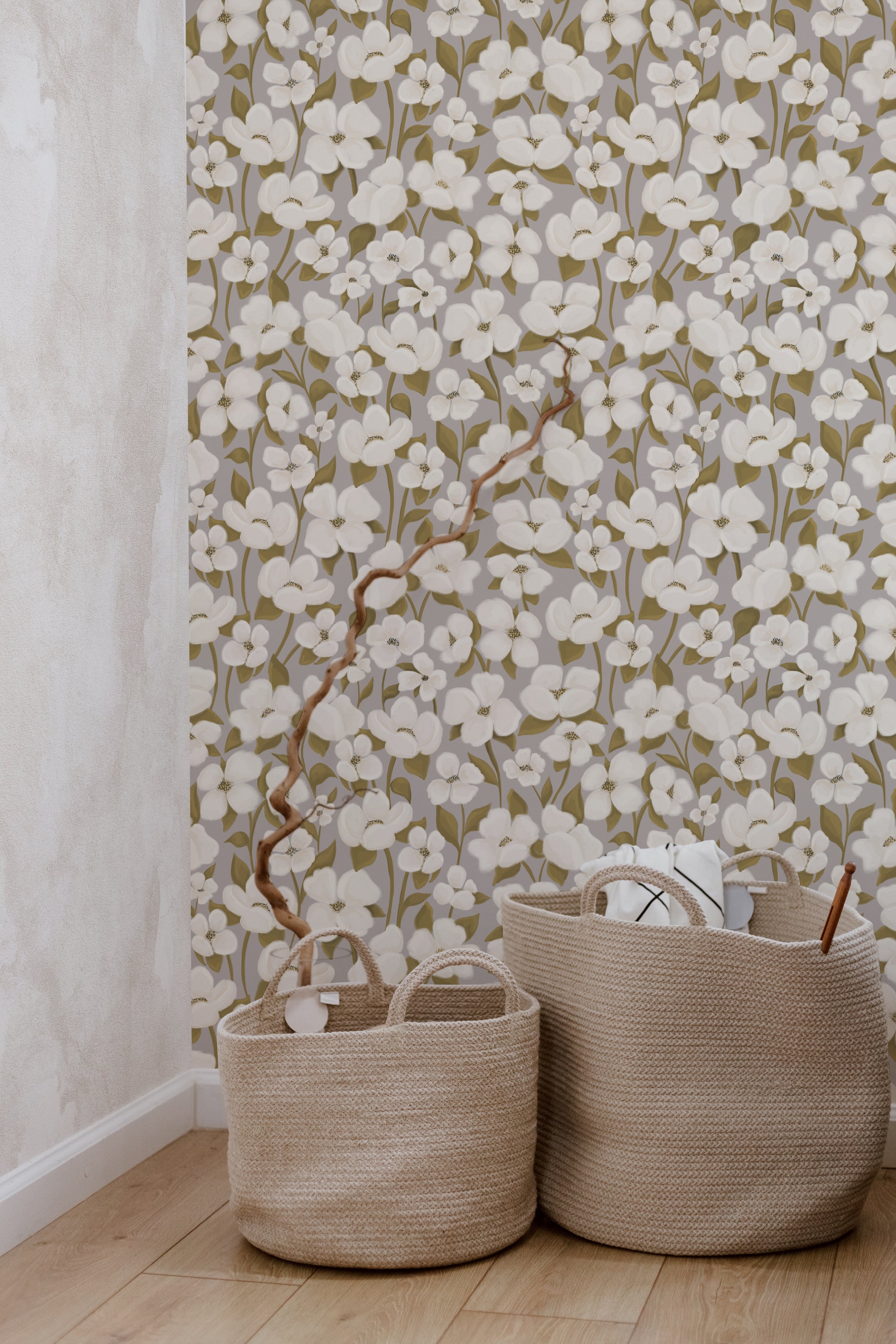 Interior scene with White Fleur Wallpaper featuring clusters of white flowers on slender branches, set against a muted olive background, complemented by two wicker baskets in the foreground.