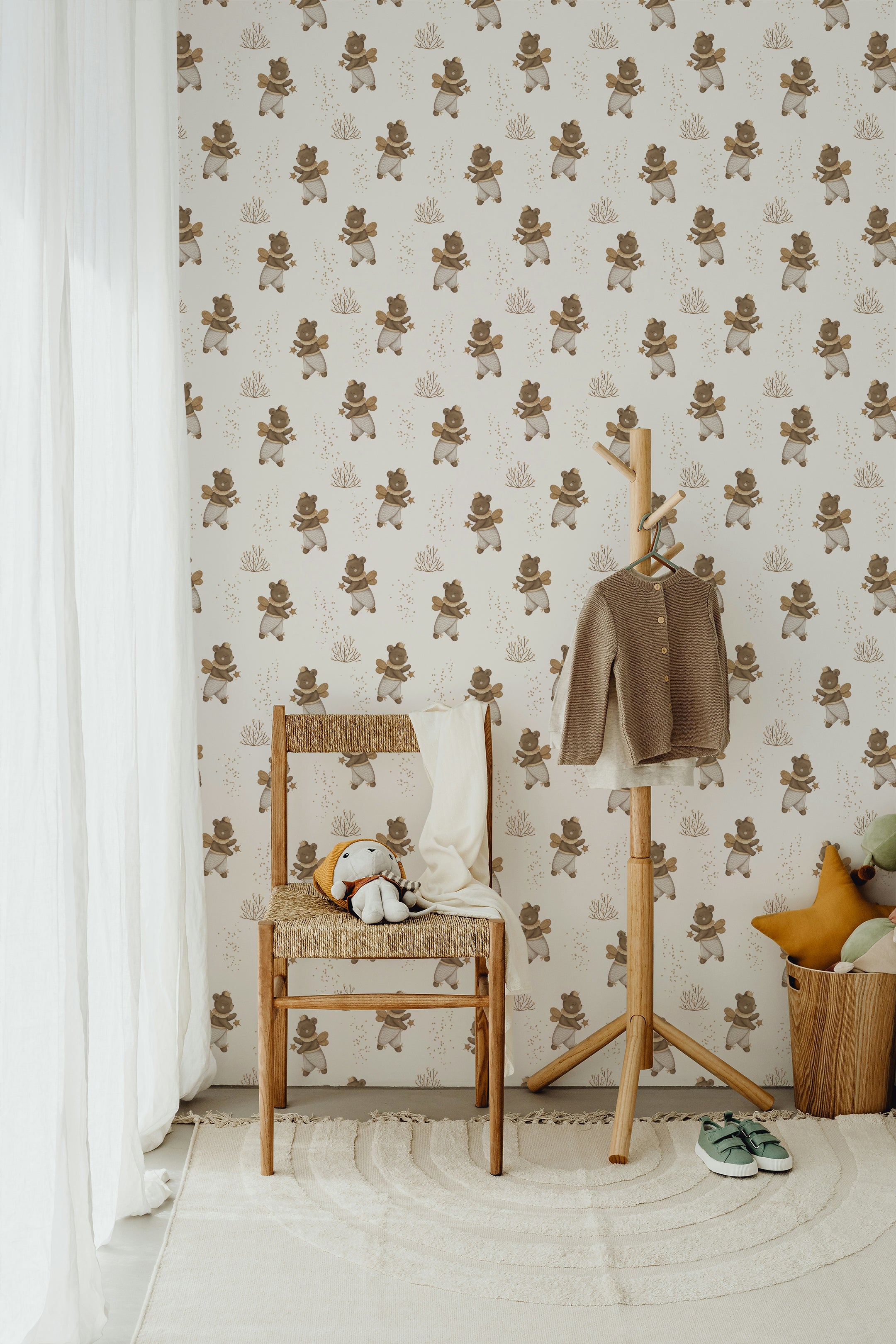 A charming corner of a nursery with Stardust Bears Wallpaper, a wooden chair, and a coat rack. Soft toys and cozy decor complete the inviting space.