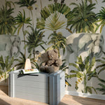 Interior shot showing a room adorned with Elephant and Palm Wallpaper - 75", which depicts a rich tropical scene including an elephant, various palms, and a cockatoo, enhancing the room with a sense of adventure and natural beauty.