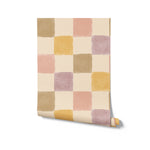 Rolled sample of Cécile Wallpaper II illustrating a gentle grid of pastel-colored squares, ideal for adding a touch of soft, calming color to any room with its stylish and versatile design