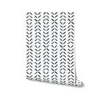 A roll of Boho Chevron Wallpaper, partially unrolled to show its distinctive chevron pattern in black on a light background. The wallpaper's dynamic and modern design makes it an ideal choice for creating an eye-catching feature wall in any room.