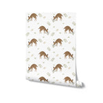 Rolled view of Forest Fawn Wallpaper displaying a repeating pattern of young fawns in natural poses with floral and leafy accents on a white background. This design is excellent for bringing a peaceful woodland feel to interiors, particularly in areas meant for rest and relaxation.