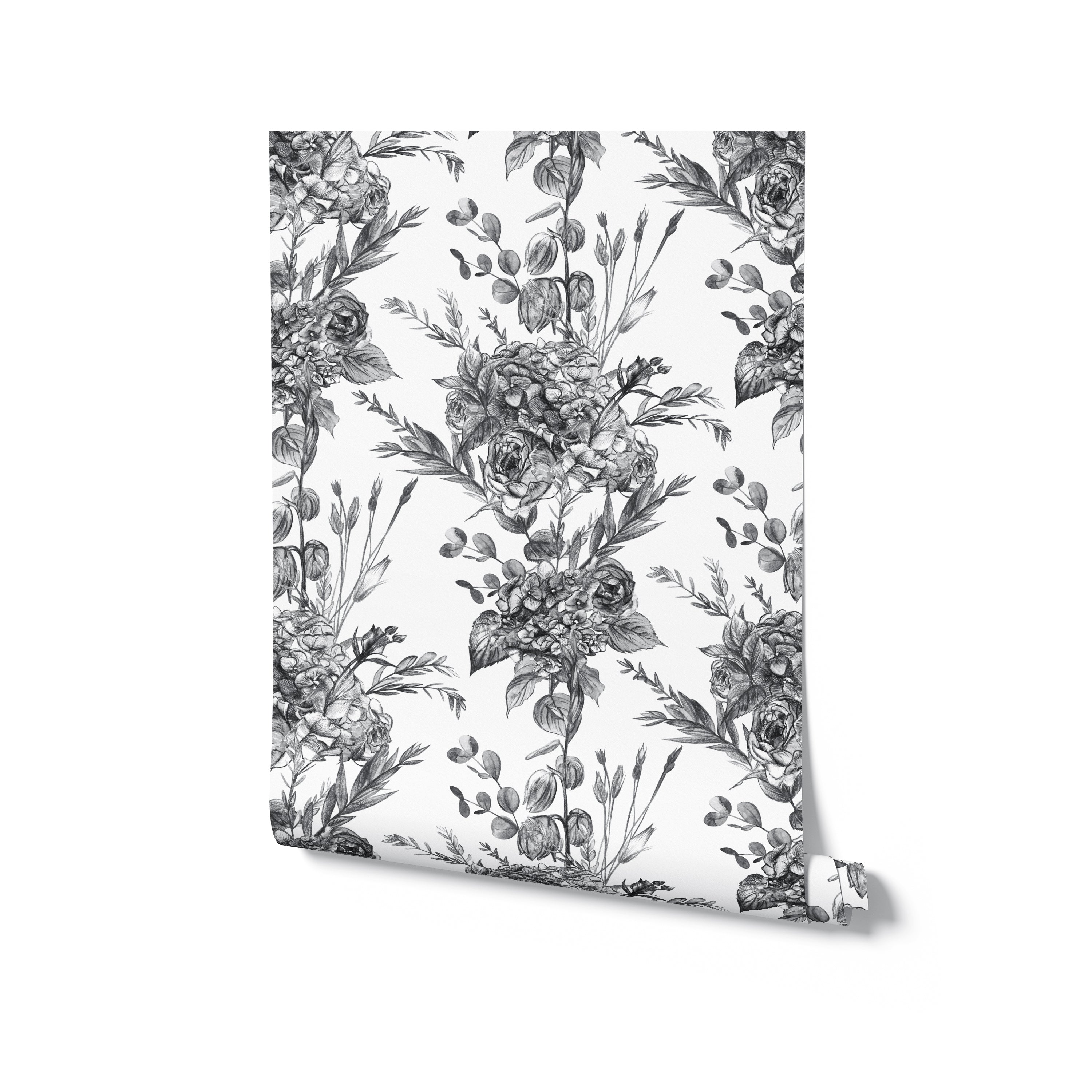 A roll of Graphite Garden Wallpaper showcasing its detailed floral pattern in grayscale. The wallpaper is neatly rolled, highlighting the intricate design and quality of the material, ideal for adding a touch of elegance to any room.